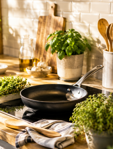 Poêle, herbes fraîches et ustensiles prêts pour un cours de cuisine
